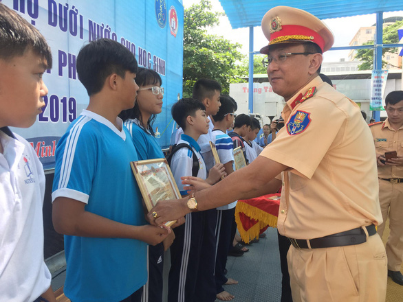 Waterway traffic police officers present prizes to students at the Lam Son swimming pool on Tran Binh Trong Street, District 5, Ho Chi Minh City, August 30, 2019. Photo: Thu Dung / Tuoi Tre