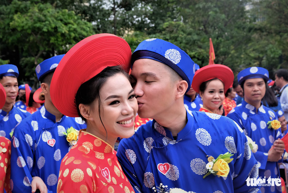 A groom kisses his bride on her cheek at a mass wedding in Ho Chi Minh City on September 2, 2019. Photo: Vu Thuy / Tuoi Tre