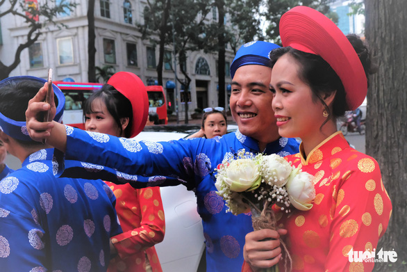 A couple takes a selfie at a mass wedding in Ho Chi Minh City on September 2, 2019. Photo: Vu Thuy / Tuoi Tre