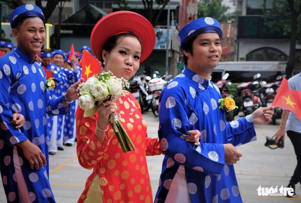 A bride walks beside her groom at a mass wedding in Ho Chi Minh City on September 2, 2019. Photo: Vu Thuy / Tuoi Tre