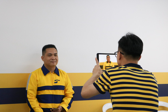 A driver for Vietnamese ride-hailing firm Be has his company ID photo taken at a Be Group office in Ho Chi Minh City on December 12, 2018. Photo: Bui Long / Tuoi Tre