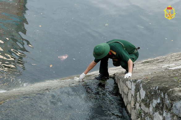 A soldier collects water samples near the Rang Dong Company in Hanoi, Vietnam for testing. Photo: People's Army of Vietnam