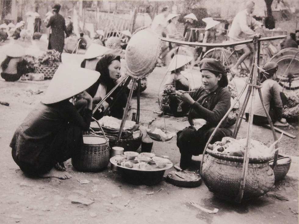 A photo capturing street vendors in Hanoi in 20th century is displayed at an exhibition in Hanoi. Photo: Thien Dieu / Tuoi Tre
