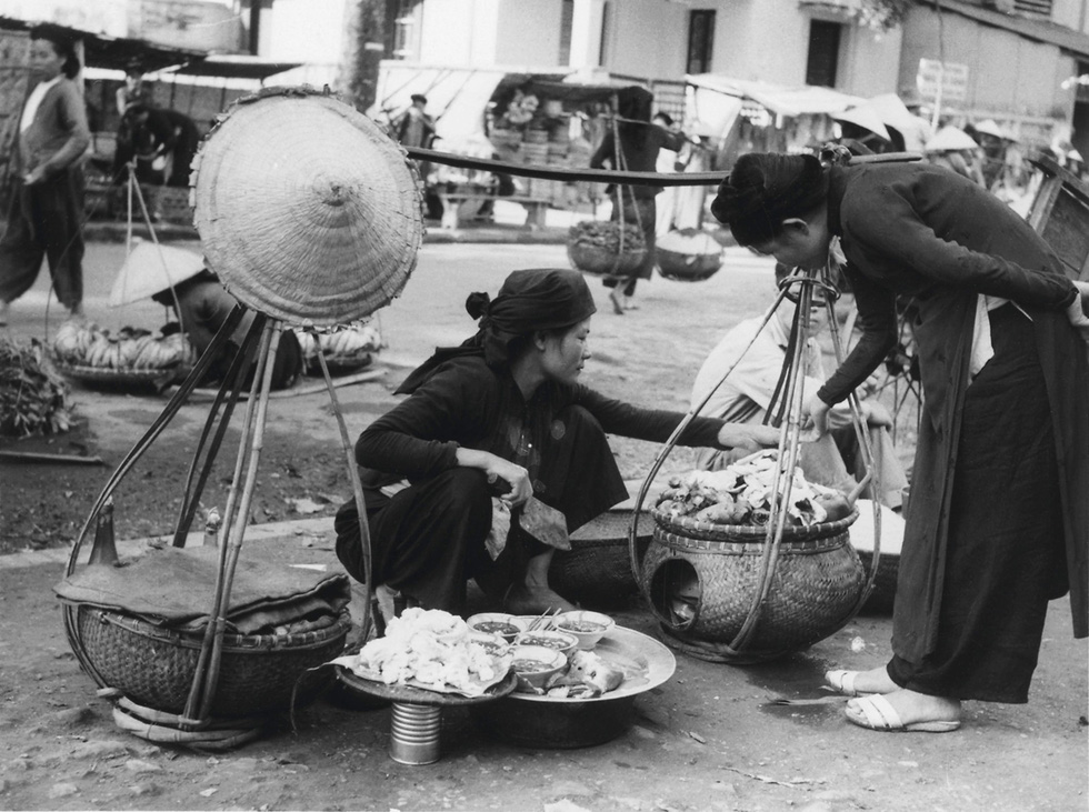 A photo capturing street vendors in Hanoi in 20th century is displayed at an exhibition in Hanoi. Photo: Thien Dieu / Tuoi Tre