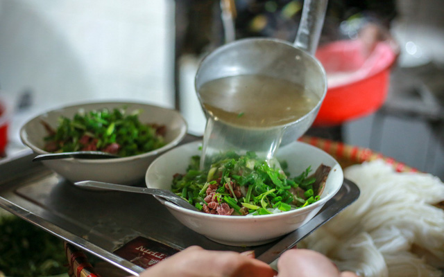 A cook pours broth onto a bowl of pho. Photo: Tuoi Tre