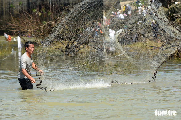 A man throws a fishing net to catch fish near the Tri An hydropower dam in Dong Nai Province, Vietnam on September 30, 2019. Photo: A Loc / Tuoi Tre