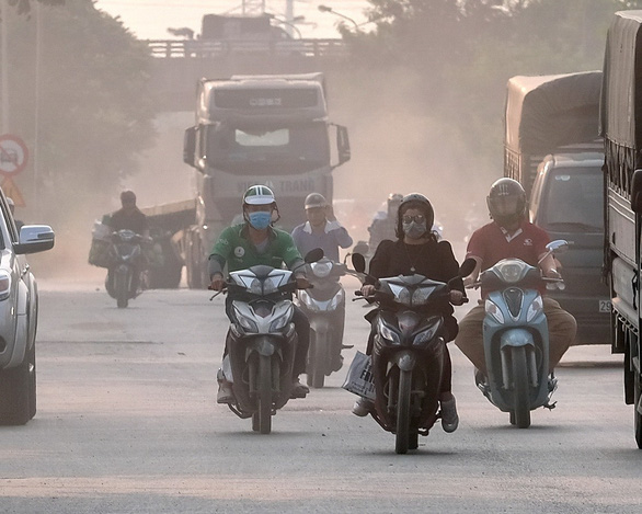 Residents commute through a screen of smoke and dust on a highway in Hanoi, Vietnam. Photo: Nam Tran / Tuoi Tre