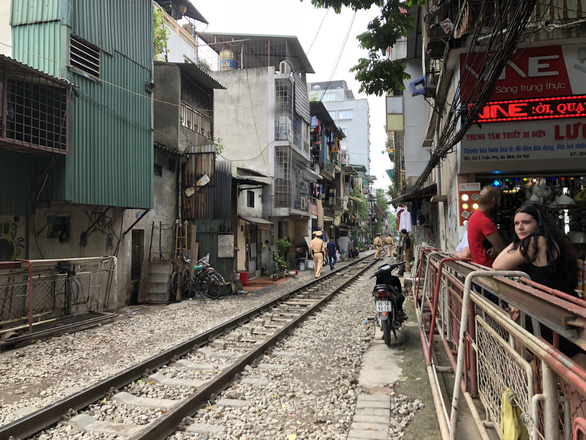 A railroad in Hanoi is empty of tourists as police officers patrol the tracks on October 10, 2019. Photo: Quang The / Tuoi Tre