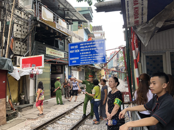 Police officers stop tourists from entering the site of once-popular trackside coffee businesses in Hanoi, Vietnam on October 10, 2019. Photo: Quang The / Tuoi Tre