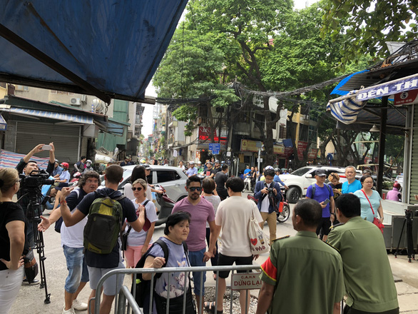 Tourists react from outside a police barrier set up around trackside coffee businesses in Hanoi, Vietnam on October 10, 2019. Photo: Quang The / Tuoi Tre