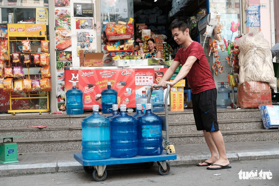 A resident in Hoang Mai District, Hanoi purchases bottled water on October 13, 2019. Photo: Mai Thuong / Tuoi Tre