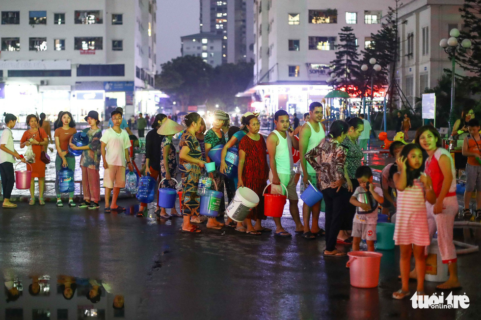 Residents at an apartment complex in Hoang Mai District, Hanoi wait for their turn to receive fresh water on October 16, 2019. Photo: Nguyen Khanh / Tuoi Tre