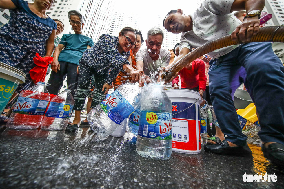 Residents at an apartment complex in Hoang Mai District, Hanoi wait for their turn to receive fresh water on October 16, 2019. Photo: Nguyen Khanh / Tuoi Tre