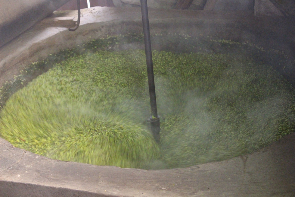 Green sticky rice is roasted in the manual oven at Nguyen Thi Can’s house in Hanoi. Photo: Ha Thanh / Tuoi Tre