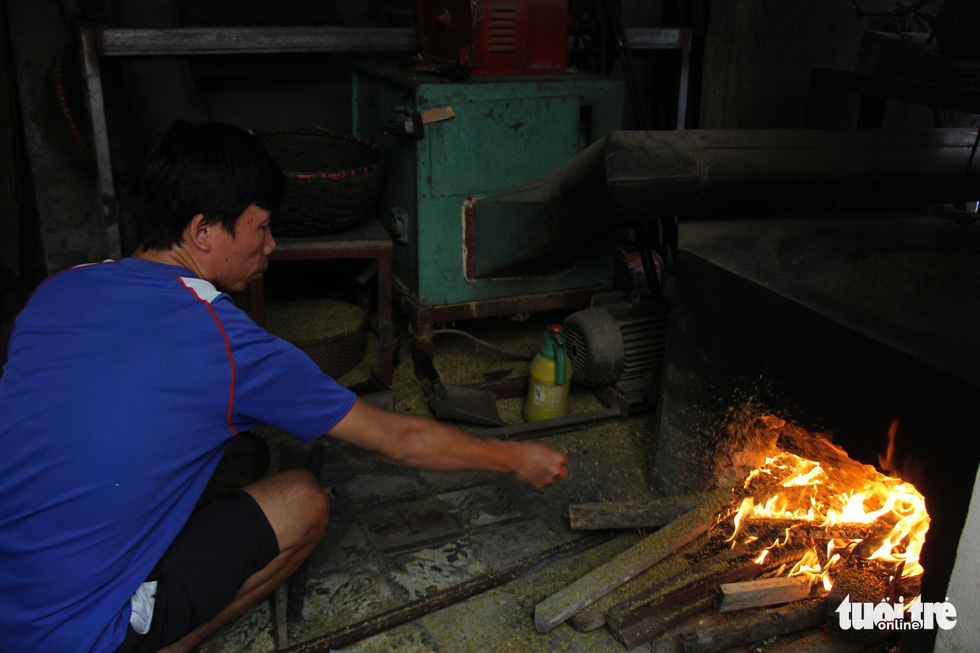 Dinh Van Chien fires the oven to roast green sticky rice at his house in Hanoi. Photo: Ha Thanh / Tuoi Tre