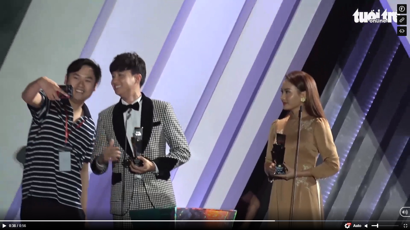 A man (L) takes a ‘we-fie’ with Vietnamese actor Quoc Truong (C) after storming the stage during the actor’s acceptance speech at the Asia Artist Award 2019 in Hanoi, Vietnam in this screen grab taken from the live broadcast of the event.