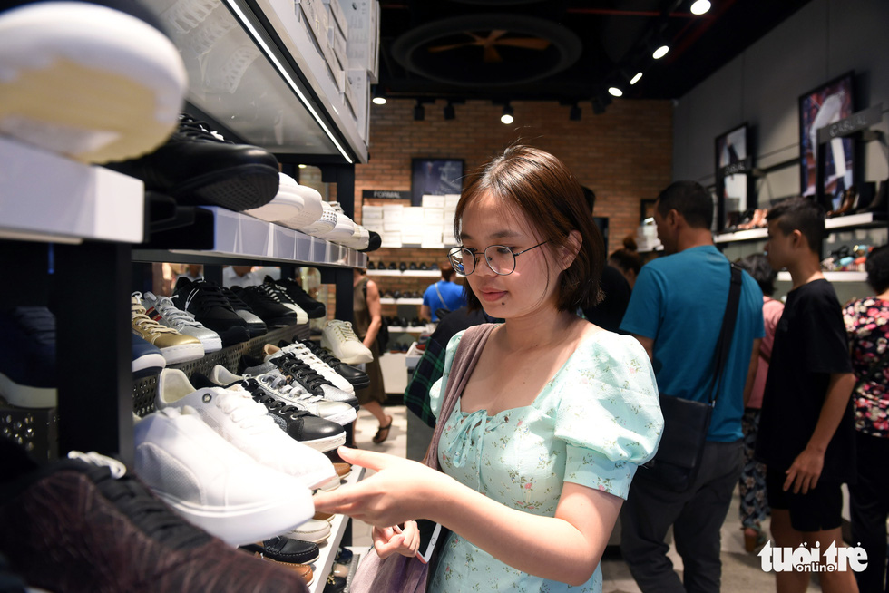 A young woman shops for shoes at a store inside Vincom Center in District 1, Ho Chi Minh City on November 29, 2019. Photo: Duyen Phan / Tuoi Tre