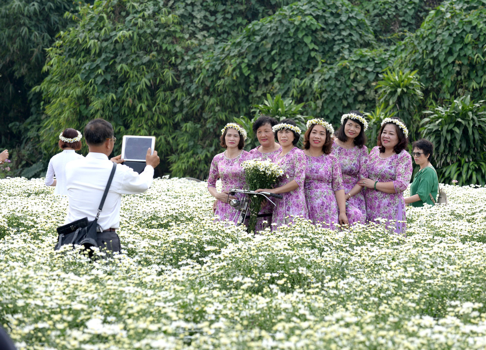 Women pose for a photo with daisies in Hanoi. Photo: T.T.D. / Tuoi Tre