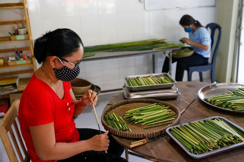 Workers make straws from grass at the 3T workshop in Long An province. Photo: Reuters