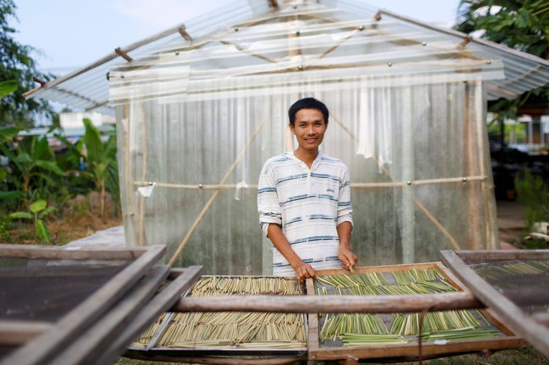 Tran Minh Tien, owner of 3T shop that makes grass straws, poses for a portrait in front of his workshop in Long An province. Photo: Reuters