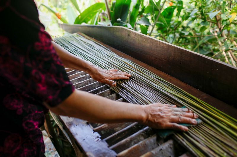 A worker washes grass collected to make straws at the 3T workshop in Long An province. Photo: Reuters