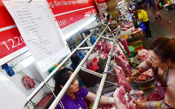 A woman buys pork at a wet market in Ho Chi Minh City. Photo: Quang Dinh / Tuoi Tre