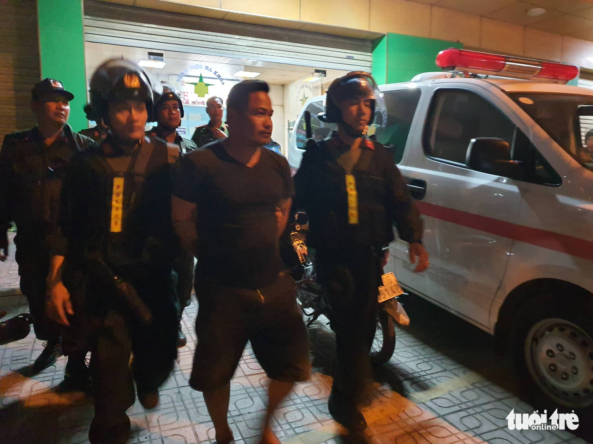 A suspect is escorted out of the hospital. Photo: S.D / Tuoi Tre