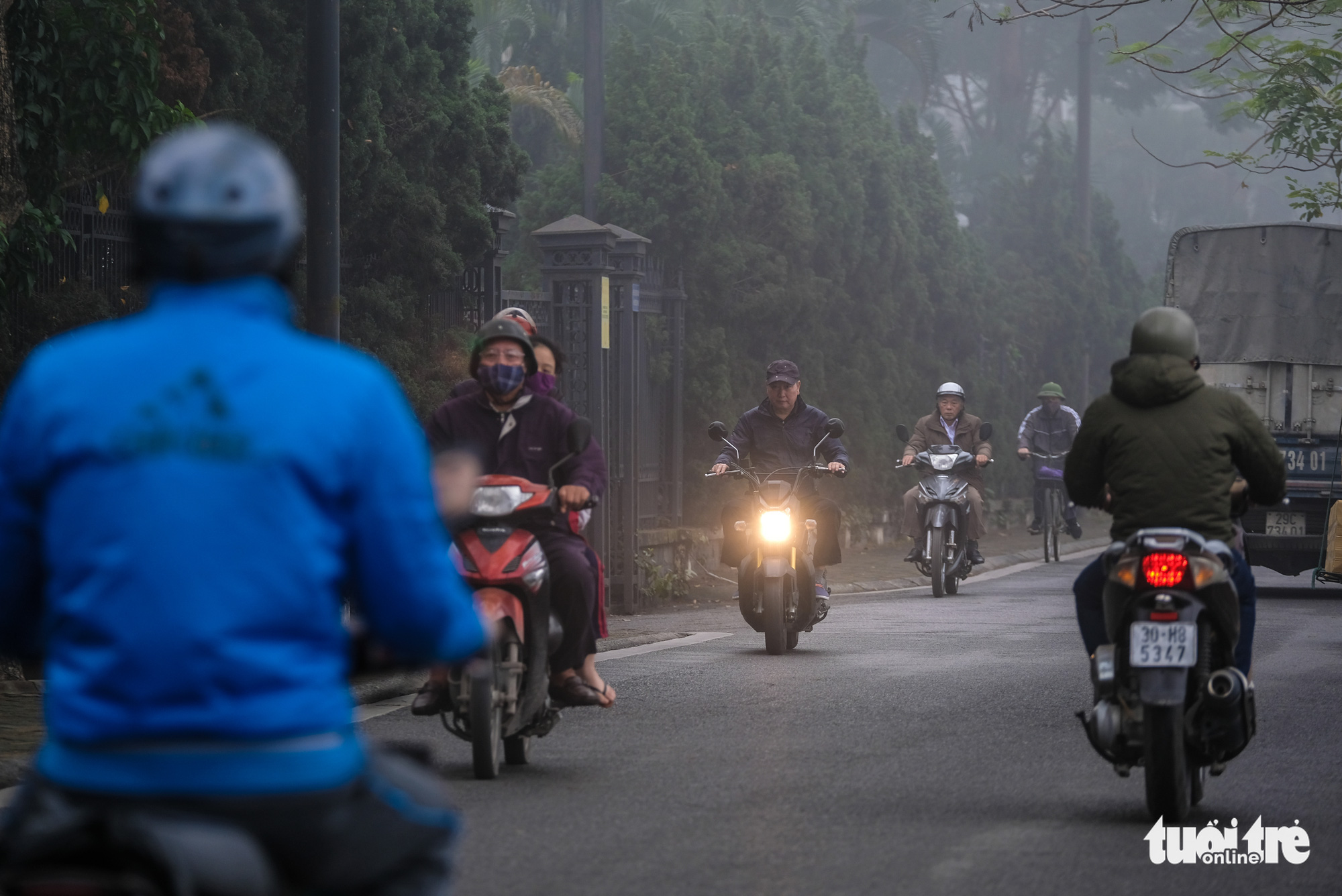 Commuters turn on their headlights in the foggy weather in Hanoi on December 24, 2019.