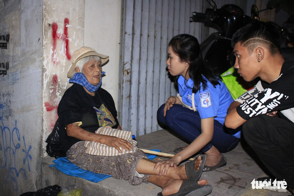 Volunteers chat with a homeless woman on the street in Ho Chi Minh City on December 23, 2019. Photo: Cong Trieu / Tuoi Tre