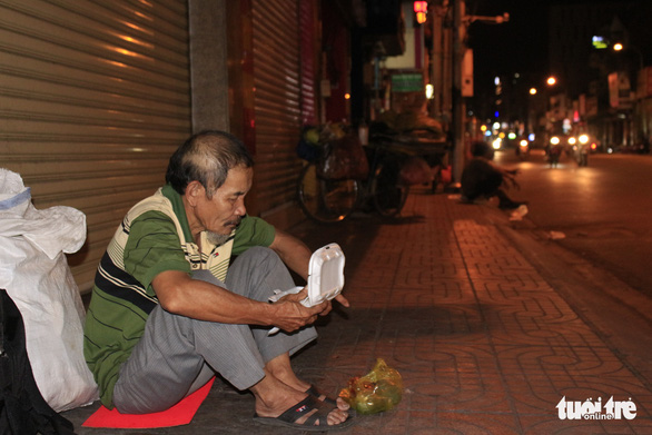 Nguyen Tan, 65, eats the food given to him by a group of volunteers in Ho Chi Minh City on December 23, 2019. Photo: Cong Trieu / Tuoi Tre