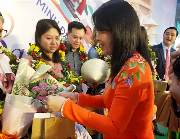 Nguyen Thi Anh Hoa, deputy director of the Ho Chi Minh City Department of Tourism, extend her compliments to new visitors touching down at Tan Son Nhat International Airport from France, January 1, 2020. Photo: Gia Khang / Tuoi Tre