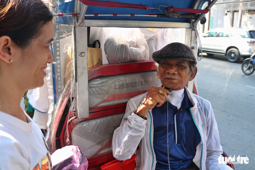 Nguyen Van Tu (R) talks with a woman on a street in Ho Chi Minh City. Photo: Ngoc Phuong / Tuoi Tre