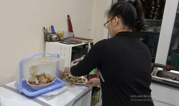 A woman prepares food for apartment-to-apartment delivery service. Photo: Tam Le / Tuoi Tre