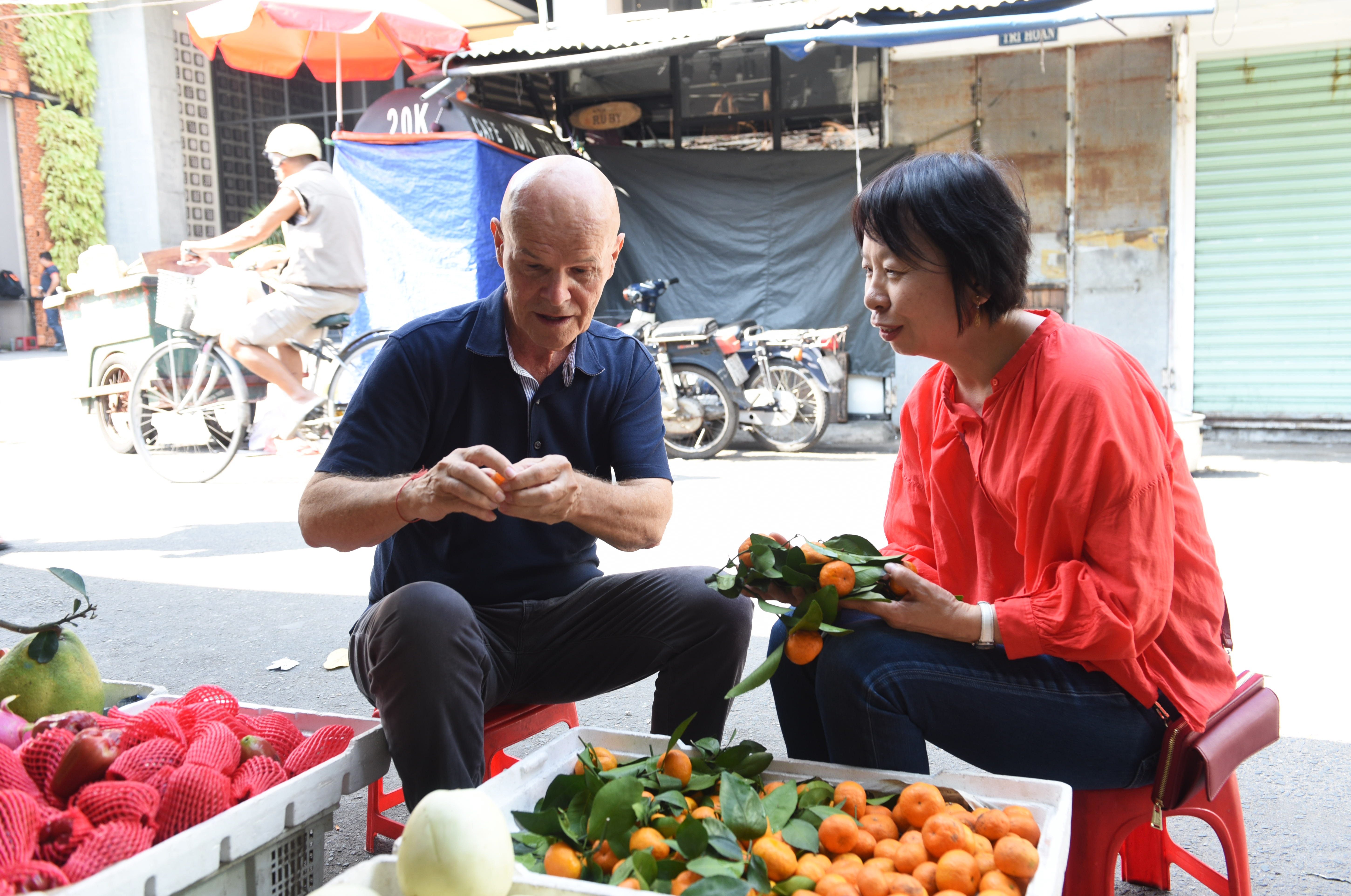 American retiree L. Dennis Woolbright and his Japanese wife stop by a fruit shop at a wet market in Ho Chi Minh City's District 1 on December 31, 2019 during her trip to Vietnam to visit her husband who moved to the country alone two years ago. Photo: Tuoi Tre/ Duyen Phan