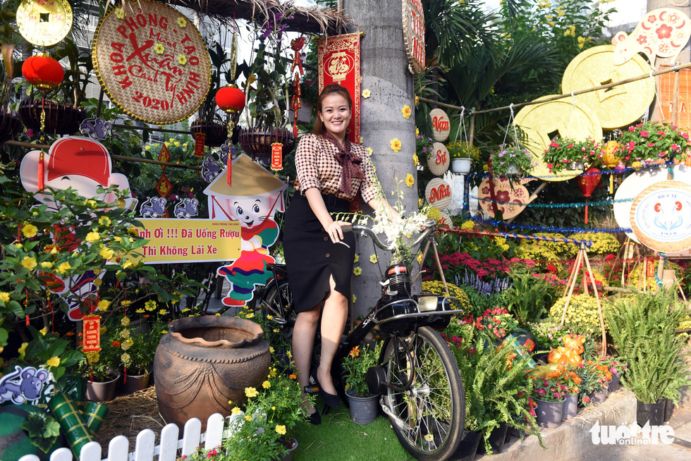 A woman poses for a picture along the ‘flower road’ at Cho Ray Hospital in Ho Chi Minh City. Photo: Duyen Phan / Tuoi Tre