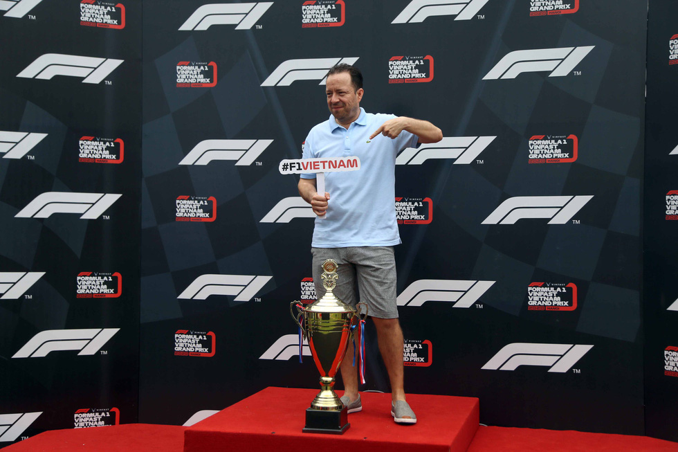 A foreign man poses with an F1 trophy design at the Vinhomes Central Park urban area in Binh Thanh District, Ho Chi Minh City on January 12, 2020. Photo: N.K / Tuoi Tre