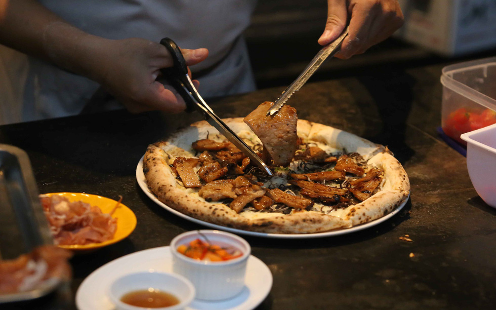 Chef Bui The Vinh is seen making cơm tấm pizza at Pizza 4P's. Photo: Tuoi Tre/ Gia Tien