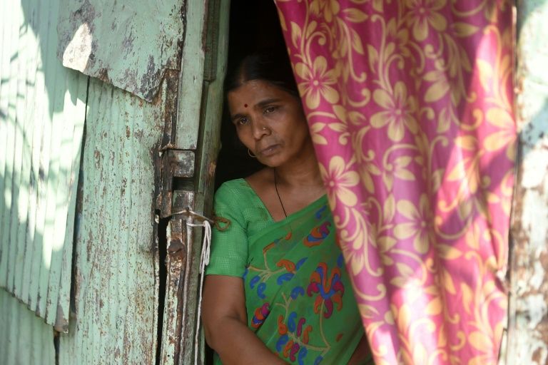 Saroj Ahire, a domestic worker, stands at the entrance to her house as she speaks with AFP in the Colaba fisherman colony in Mumbai. Photo: AFP