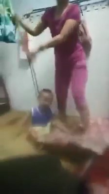 A screenshot from a footage showing N.T.T.T. beating her child after putting a lasso on his neck