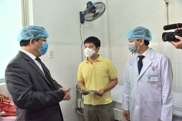 Li Zichao (C) talks to Luong Ngoc Khue (L), an official from Vietnam's Ministry of Health, at Cho Ray Hospital in Ho Chi Mnh City, February 4, 2020. Photo: Duyen Phan / Tuoi Tre