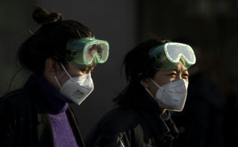 Two women wear face masks and swimming goggles in China. Photo: AFP
