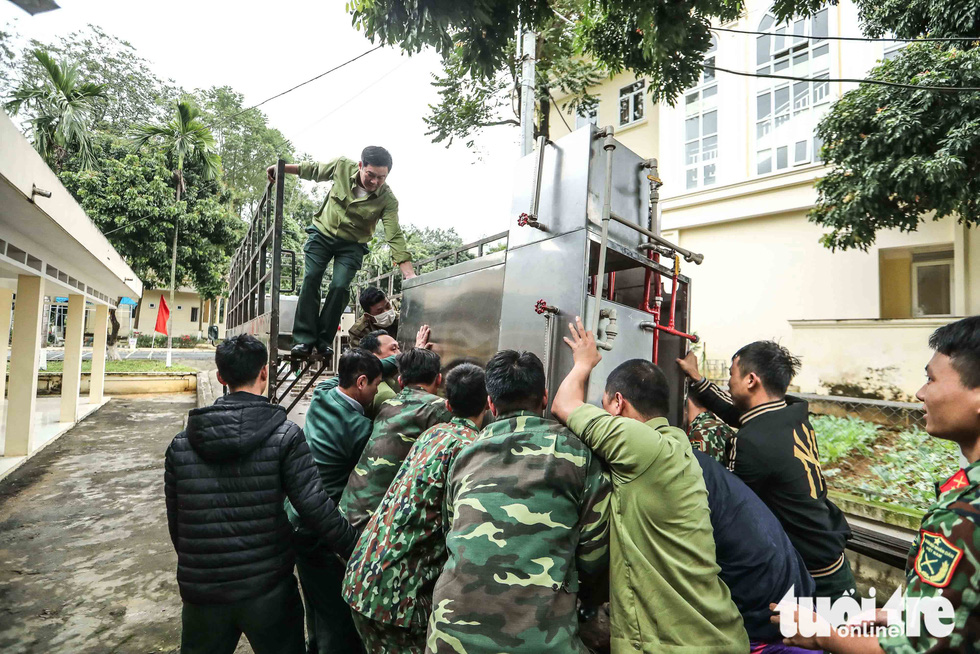 Staff move a cooking equipment at the 59th Infantry Regiment in Chuong My District, Hanoi, on February 6, 2020. Photo: Nguyen Khanh / Tuoi Tre