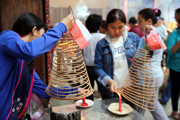 <em>People light incense at the First Full Moon Festival, or Tet Nguyen Tieu, at a pagoda in District 5, Ho Chi Minh City.</em>