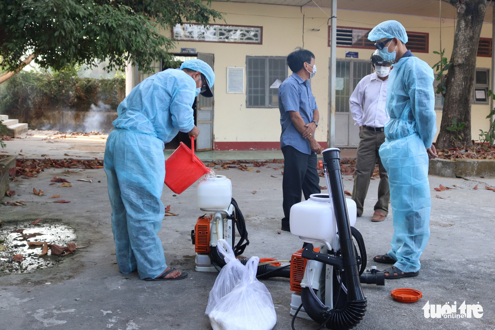 Staff mix the disinfectant Cloramin B with water before spraying at a venue in the southernmost Vietnamese province of Ca Mau. Photo: Khanh Tran / Tuoi Tre