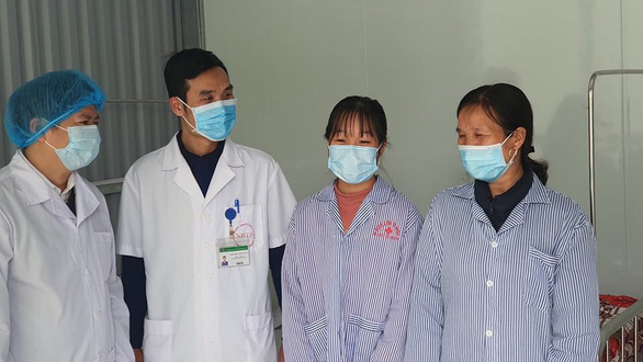 Two COVID-19 patients (R) are released from a local general clinic in the northern province of Vinh Phuc, Vietnam, February 20, 2020. Photo: Thuy Anh / Tuoi Tre
