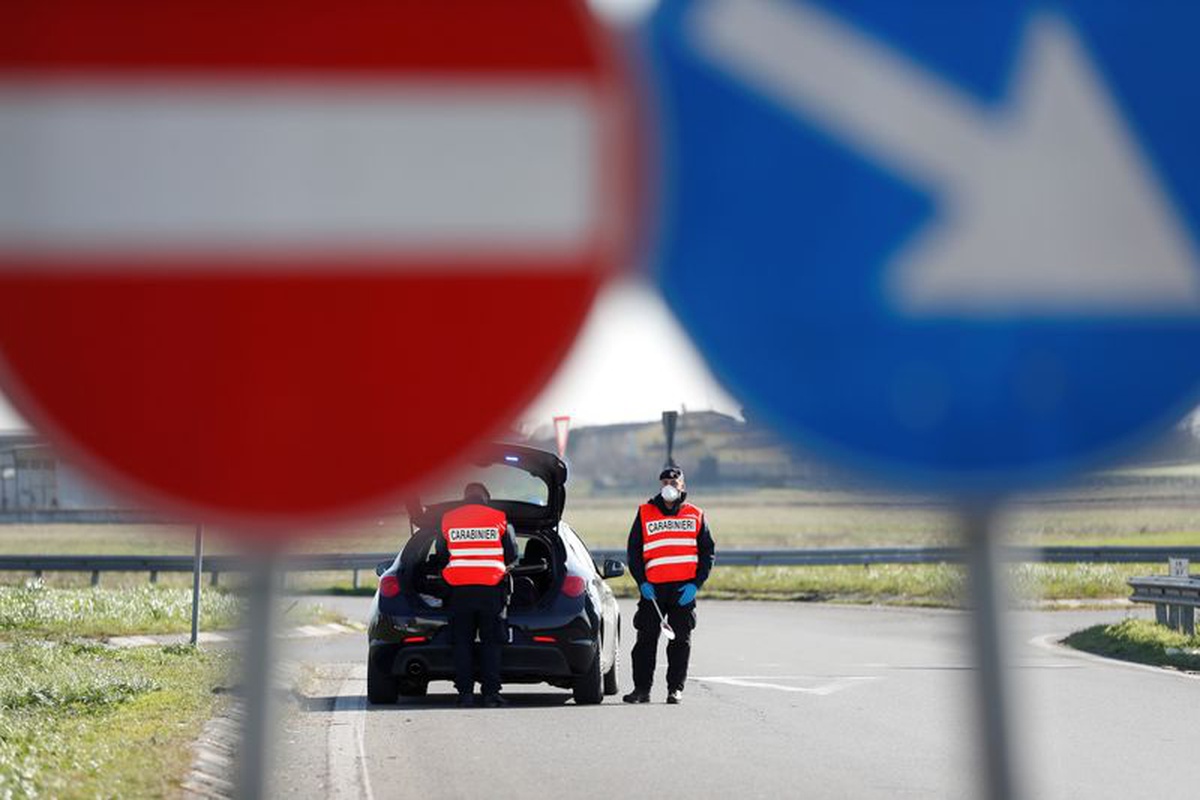 Members of the Italian Carabinieri wear face masks as they guard the entrance of the red zone of Casalpusterlengo, closed off due to a coronavirus outbreak in northern Italy, February 26, 2020. Photo: Reuters