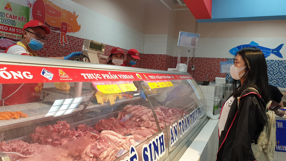 A woman wears face mask as as she shops for discounted meat at a Co.opmart supermarket in on March 1, 2020. Photo: Bong Mai / Tuoi Tre