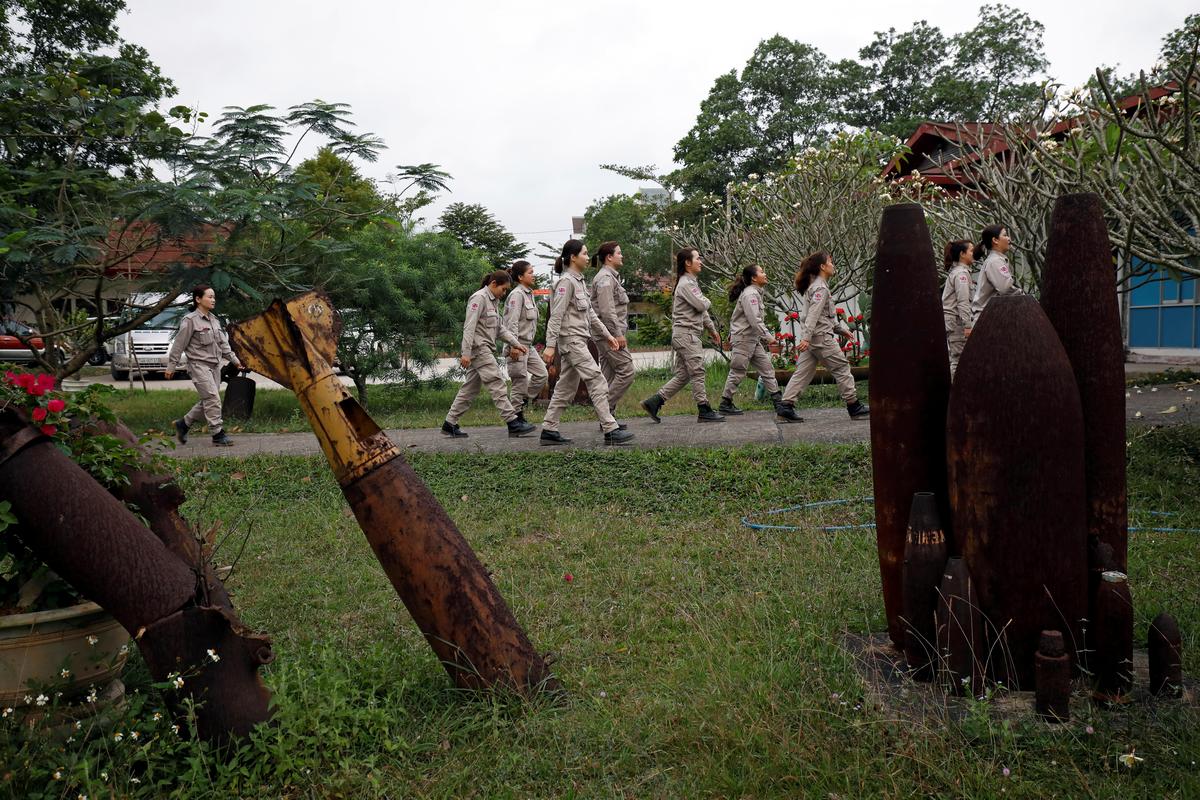 Members of all-female landmines clearance team walk past the shells of U.S. military bombs used during Vietnam War, at a bombs and landmines exhibition in Quang Tri province, Vietnam March 4, 2020. Picture taken March 4, 2020. Photo: Reuters