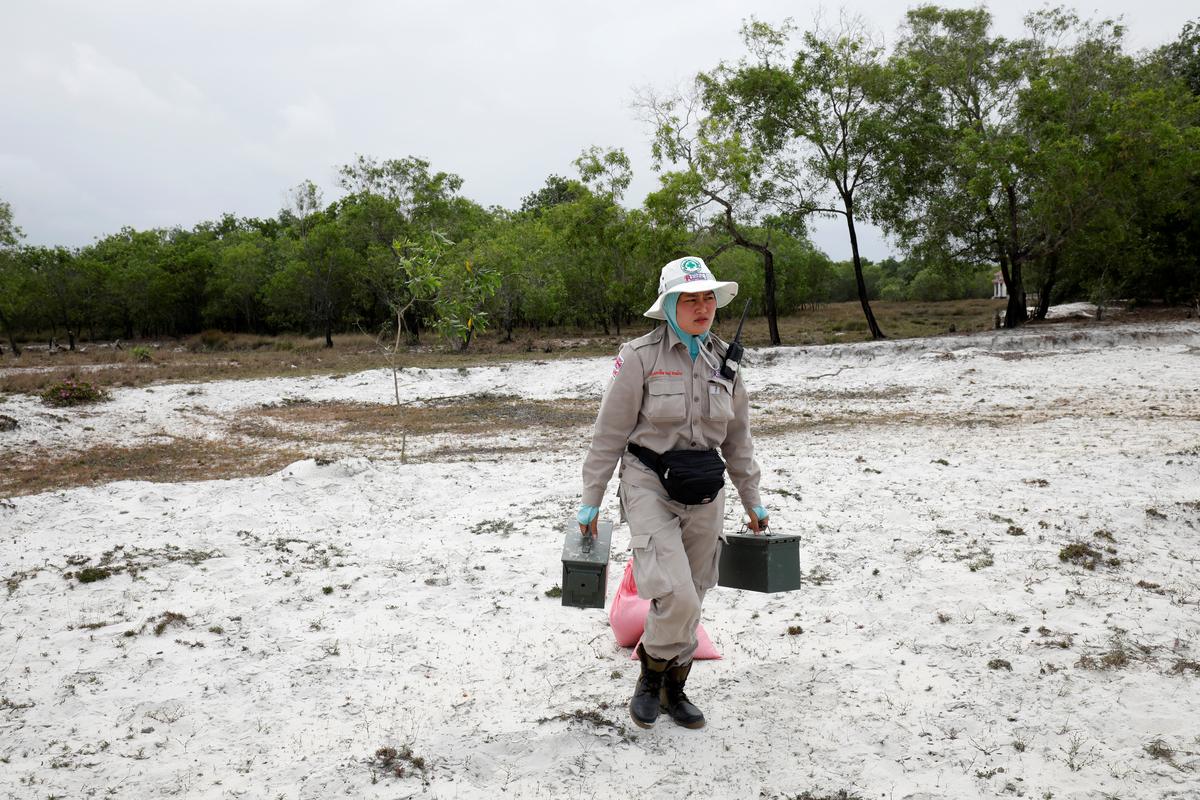 Captain Nguyen Thi Thuy of all-female landmines clearance team carries boxes of detonators to destroy unexploded ordnances found on a field in Quang Tri province, Vietnam March 4, 2020. Picture taken March 4, 2020. Photo: Reuters