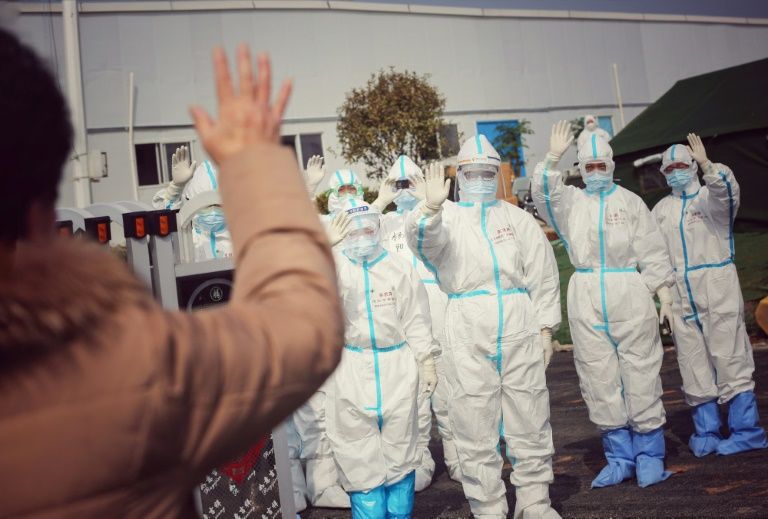Medical staff members wave to a recovered patient at a makeshift hospital for the COVID-19 coronavirus patients in Wuhan. Photo: AFP